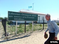 Ауылдық әкімдік кеңсесі алдынан өтіп бара жатқан адам. Мақат ауданы, Атырау облысы, шілде, 2009 жыл. Көрнекі сурет.