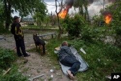 Вовчанскіде Ресей әскерінің соққысынан кейін үйінің жанып жатқанына қарап тұрған тұрғын. Украина, 11 мамыр 2024 жыл.