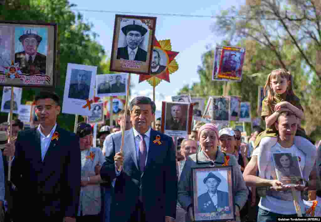 Амалдаги президент Сўўрўнбай Жээнбеков бобоси Жээнбек Пирназаровнинг суратини кўтариб ўтди.